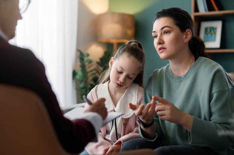 Parent and child sitting together with a counsellor during a developmental screening consultation