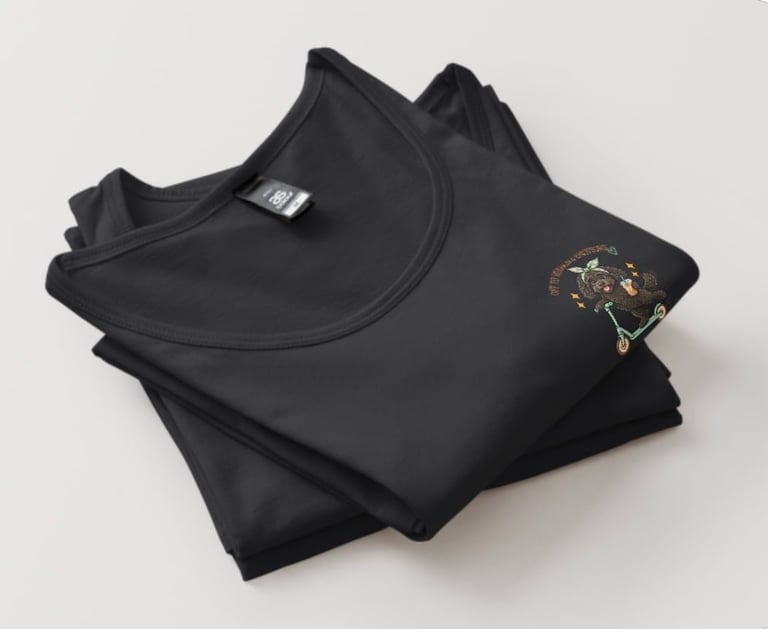 Folded black sweatshirt with small graphic design on chest and care label visible